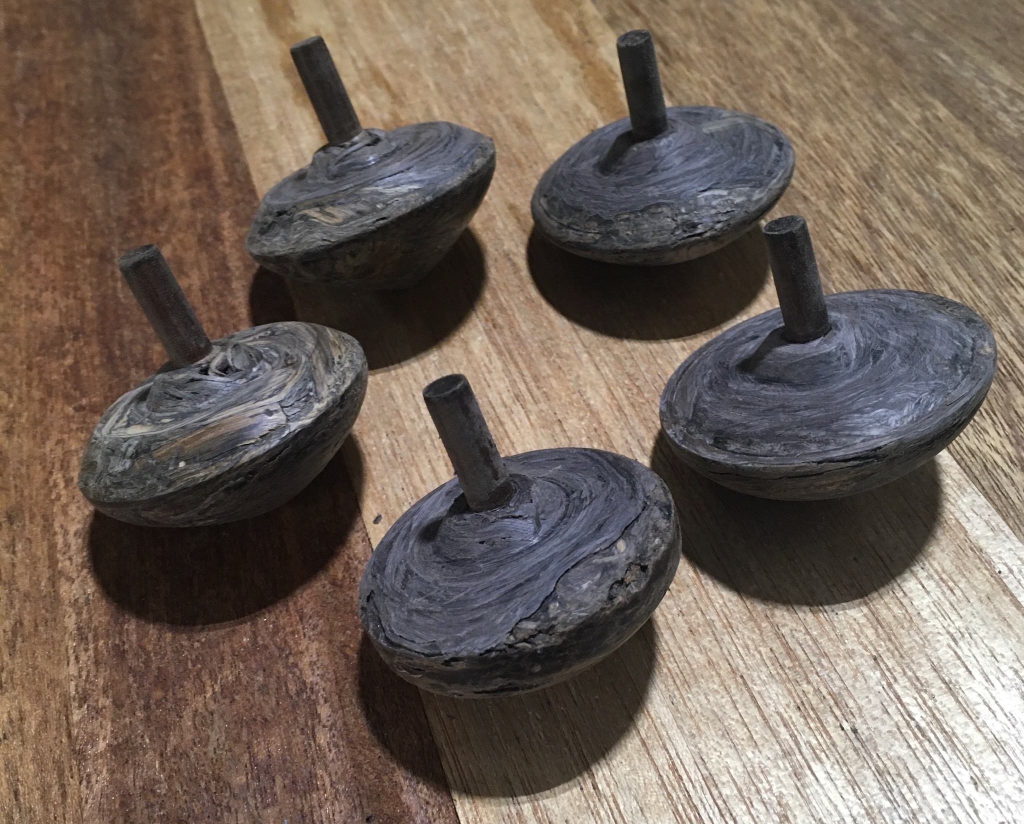 Spinning tops made from blackerry canes. They are a dark varied colour.